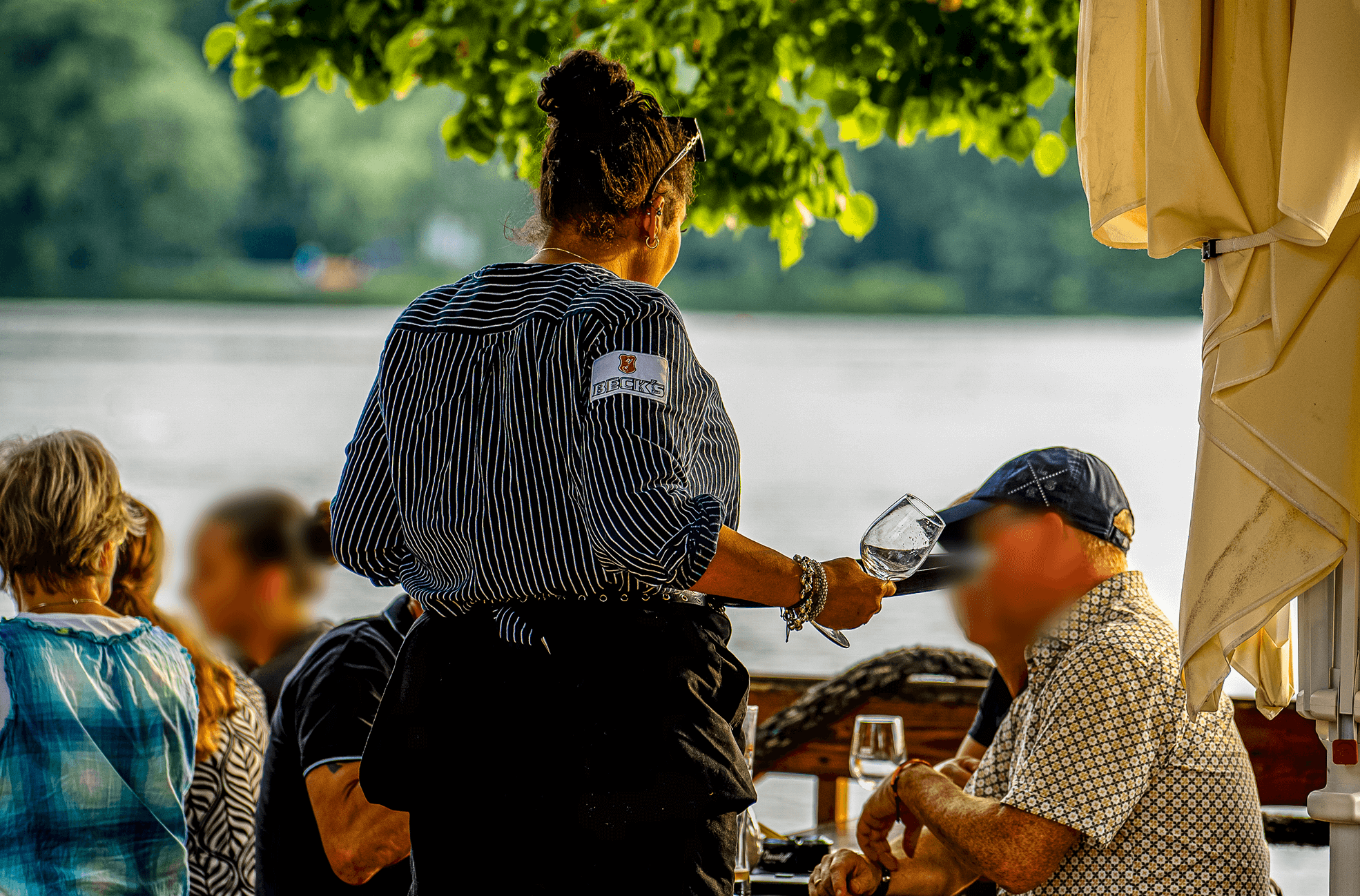 Kellnerin am Tisch eines Restaurants am Wasser
