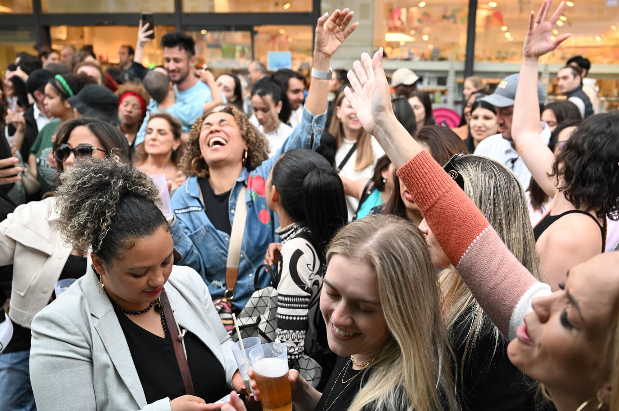 Eine Gruppe von Menschen tanzt und hebt fröhlich die Hände.